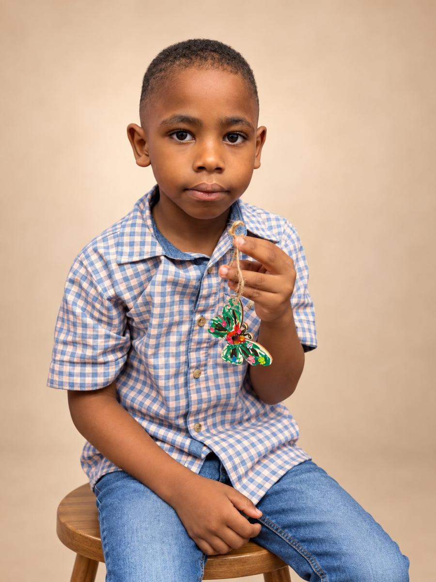 Boy holding his painted butterfly ornament